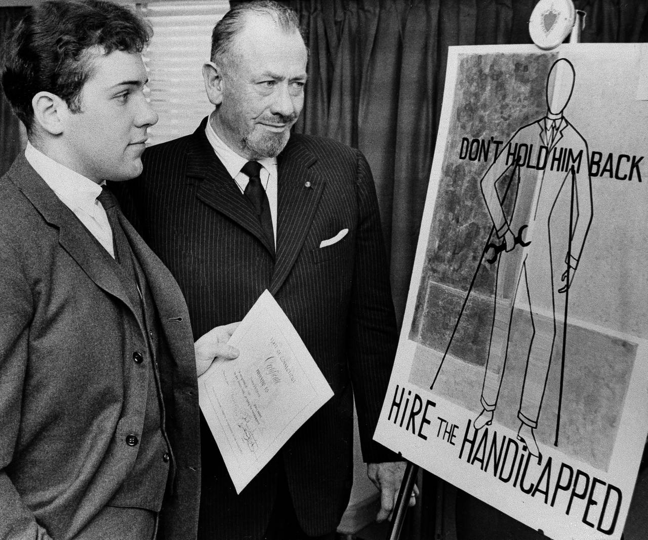 FILE — Nobel prize-winning author John Steinbeck, right, admires a prize-winning poster by his so...