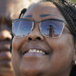 
              Sarah H. Jackson's sunglasses reflect the Emmett Till statue during its unveiling, Friday, Oct. 21, 2022 in Greenwood, Miss. Till was a 14-year-old African American boy who was abducted, tortured, and lynched, Aug. 28,1955, after being accused of offending a white woman, in her family's grocery store in Money. (AP Photo/Rogelio V. Solis)
            