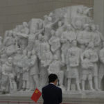 
              A visitor to the Museum of the Communist Party of China holds a party flag near a sculpture depicting heroic workers in Beijing, Wednesday, Oct. 12, 2022. For decades Chinese journalist Ho Pin has successfully predicted rising newcomers in the Chinese Communist Party, and says that leader Xi Jinping is so powerful, there is little point in predicting the leadership line up to be announced at the Communist Party congress that begins Sunday. (AP Photo/Ng Han Guan)
            