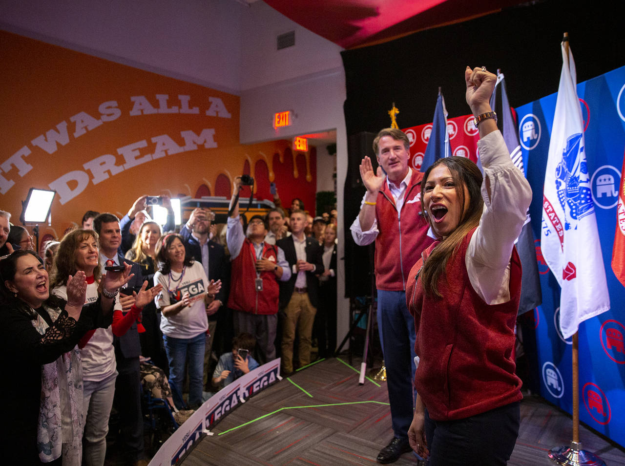 Yesli Vega, right, and Gov. Glenn Youngkin cheer with the crowd during a rally at Gourmeltz in Spot...