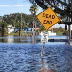 
              Houses are inundated by floodwaters on Mullet Lake Park Road on Wednesday, Oct. 5, 2022, in Geneva, Fla., as the St. Johns River continues to rise, following historic levels of rainfall from Hurricane Ian last week. (Joe Burbank/Orlando Sentinel via AP)
            