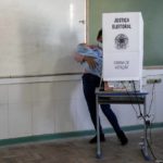 
              A woman holding a baby votes during general elections in Acegua, Brazil, Sunday, Oct. 2, 2022. (AP Photo/Matilde Campodonico)
            