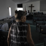 
              Barbara Wasko walks through the sanctuary of the Southwest Baptist Church in Fort Myers, Fla., Sunday, Oct. 2, 2022. She took refuge inside the church when Hurricane Ian swept through Southwest Florida. (AP Photo/Robert Bumsted)
            