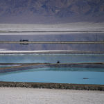 
              A truck drives between brine evaporation ponds at Albemarle Corp.'s Silver Peak lithium facility, Thursday, Oct. 6, 2022, in Silver Peak, Nev. The ponds use evaporation to help separate lithium from brine pumped from underground. The Biden administration on Wednesday, Oct. 19, awarded $2.8 billion in grants to build and expand domestic manufacturing of batteries for electric vehicles in 12 states. A total of 20 companies, including Albemarle Corp., will receive grants for projects to extract and process lithium, graphite and other battery materials, manufacture components and strengthen U.S. supply of critical minerals, officials said. (AP Photo/John Locher)
            