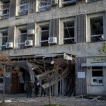 
              Police officers stand near a damaged building after a Russian attack in Kyiv, Ukraine, Monday, Oct. 10, 2022. Russia unleashed a lethal barrage of strikes against multiple Ukrainian cities Monday, smashing civilian targets including downtown Kyiv where at least six people were killed amid burnt-out cars and shattered buildings. (AP Photo/Roman Hrytsyna)
            