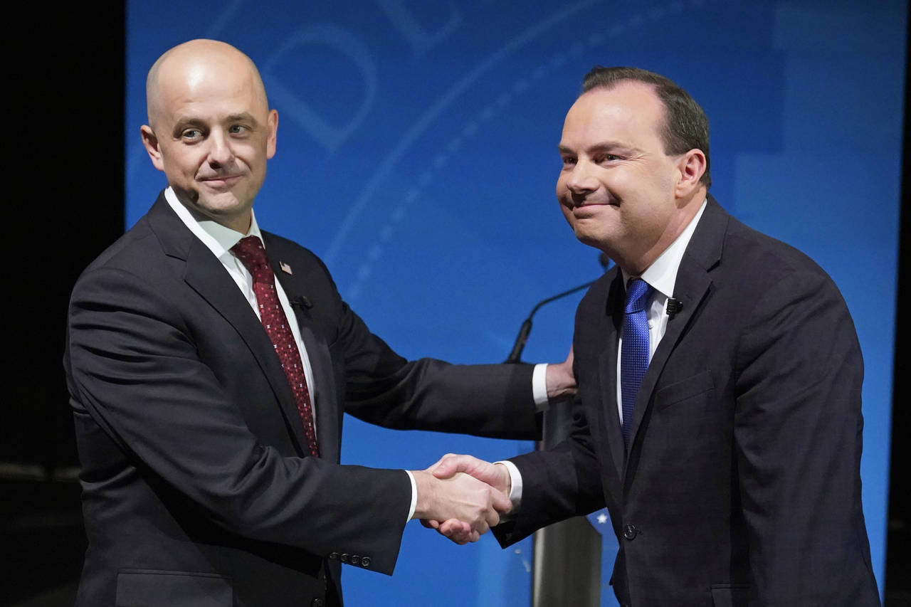 Utah Republican Sen. Mike Lee, right, and his independent challenger Evan McMullin shake hands befo...