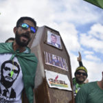 
              FILE - Supporters of Brazil's President Jair Bolsonaro carry a coffin with images of the resigned former Justice Minister Sergio Moro taped to it, during a protest against the Supreme Court and Brazil's National Congress, in Brasilia, Brazil, Sunday, May 17, 2020. The anti-corruption crusader had Brazil's former President da Silva jailed. But then the Supreme Court ruled that Moro had been biased against Luiz Inacio Lula da Silva by colluding with prosecutors to secure a conviction. (AP Photo/Andre Borges, File)
            