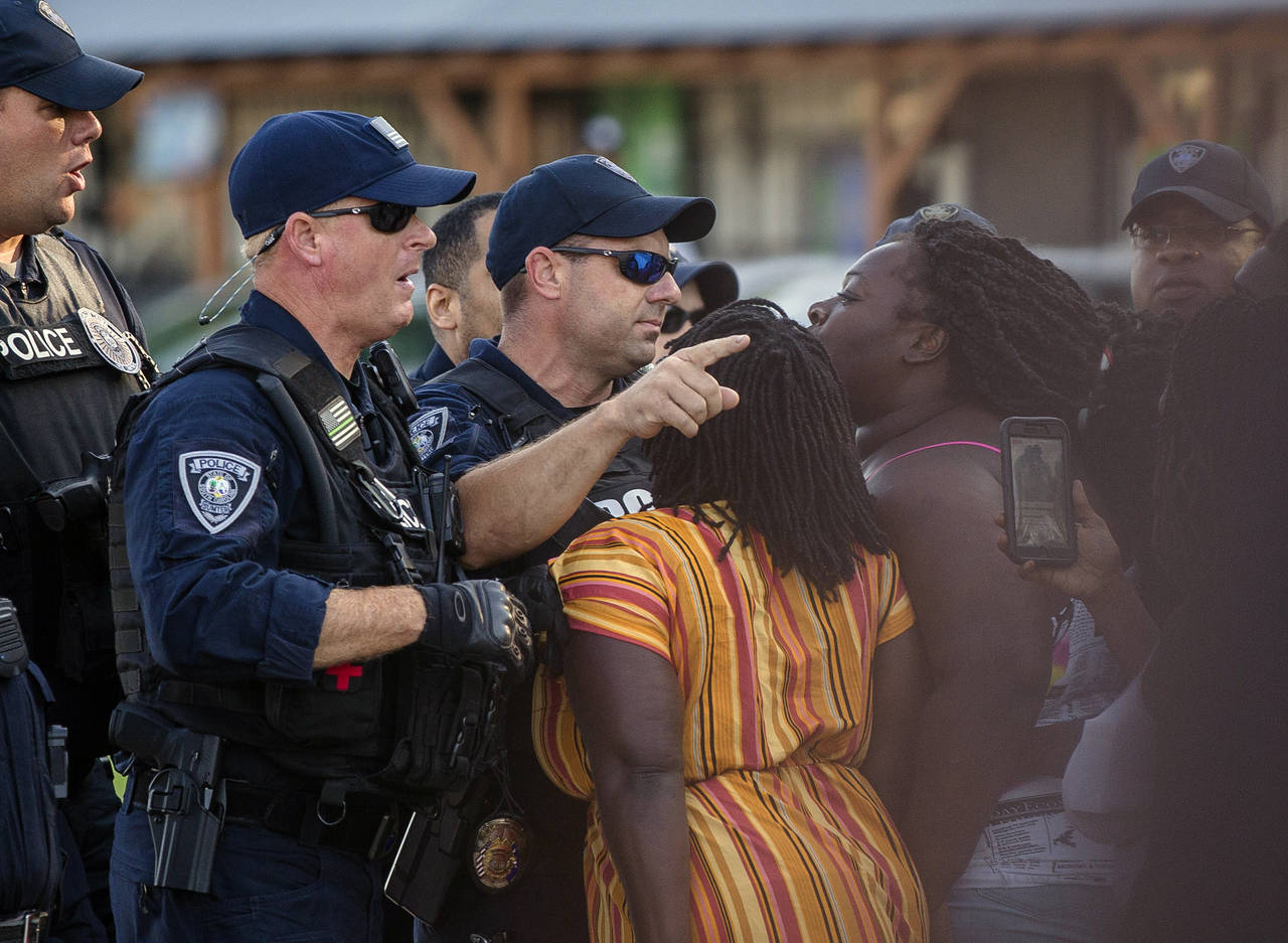 FILE - Brittany Martin, center, wearing striped clothing, confronts police as demonstrators in supp...