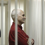 
              FILE- Ales Bialiatski, the jailed leader of Vesna, the most prominent human rights group in Belarus, stands in a cage during a court session in Minsk, Belarus, Thursday, Nov. 24, 2011. On Friday, Oct. 7, 2022 the Nobel Peace Prize was awarded to jailed Belarus rights activist Ales Bialiatski, the Russian group Memorial and the Ukrainian organization Center for Civil Liberties.  (AP Photo/Sergei Grits, File)
            