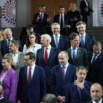 
              French President Emmanuel Macron, top center, arrives as EU leaders pose for a group photo during an EU Summit at Prague Castle in Prague, Czech Republic, Friday, Oct 7, 2022. European Union leaders converged on Prague Castle Friday to try to bridge significant differences over a natural gas price cap as winter approaches and Russia's war on Ukraine fuels a major energy crisis. (AP Photo/Petr David Josek)
            