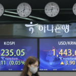 
              An employee of a bank walks by the screens showing the Korea Composite Stock Price Index (KOSPI), left, and the foreign exchange rate between U.S. dollar and South Korean won at a foreign exchange dealing room in Seoul, South Korea, Tuesday, Oct. 25, 2022. Shares advanced Tuesday in Asia after Wall Street shook off an early bout of unsettled trading and ended higher. (AP Photo/Lee Jin-man)
            