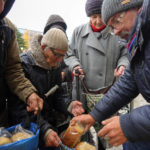 
              Local residents wait to get free bread from volunteers in Bakhmut, the site of the heaviest battle against the Russian troops in the Donetsk region, Ukraine, Friday, Oct. 28, 2022. (AP Photo/Efrem Lukatsky)
            