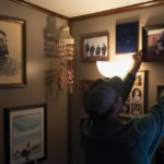 
              John Kokeok, 46, hangs a framed photo of his brother, Norman, back on the wall after an interview with The Associated Press in Shishmaref, Alaska, Monday, Oct. 3, 2022. Norman died in 2007 after his snowmobile fell through ice that melted earlier than usual. (AP Photo/Jae C. Hong)
            