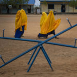 
              Women walk outside at a school in Dollow, Somalia, on Monday, Sept. 19, 2022. At midday, dozens of hungry children from the camps try to slip into a local primary school where the World Food Program offers a rare lunch program for students. (AP Photo/Jerome Delay)
            