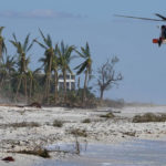 
              A U.S. Coast Guard helicopter prepares to land on the beach to ferry people off the island, in the wake of Hurricane Ian, Friday, Sept. 30, 2022, on Sanibel Island, Fla. (AP Photo/Steve Helber)
            