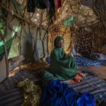 
              Fartum Issack sits in a shelter at a camp for displaced people on the outskirts of Dollow, Somalia, on Monday, Sept. 19, 2022. Issack and her husband carried a small body along a dusty track to a graveyard. Their 1-year-old daughter had arrived at camp sick and hungry. She was rushed for treatment, but it was too late. (AP Photo/Jerome Delay)
            