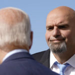 
              Pennsylvania Lt. Gov. John Fetterman, a Democratic candidate for U.S. Senate, stands on the tarmac after greeting President Joe Biden, front left, Thursday, Oct. 20, 2022, at the 171st Air Refueling Wing at Pittsburgh International Airport in Coraopolis, Pa. Biden is visiting Pittsburgh to promote his infrastructure agenda. (AP Photo/Patrick Semansky)
            