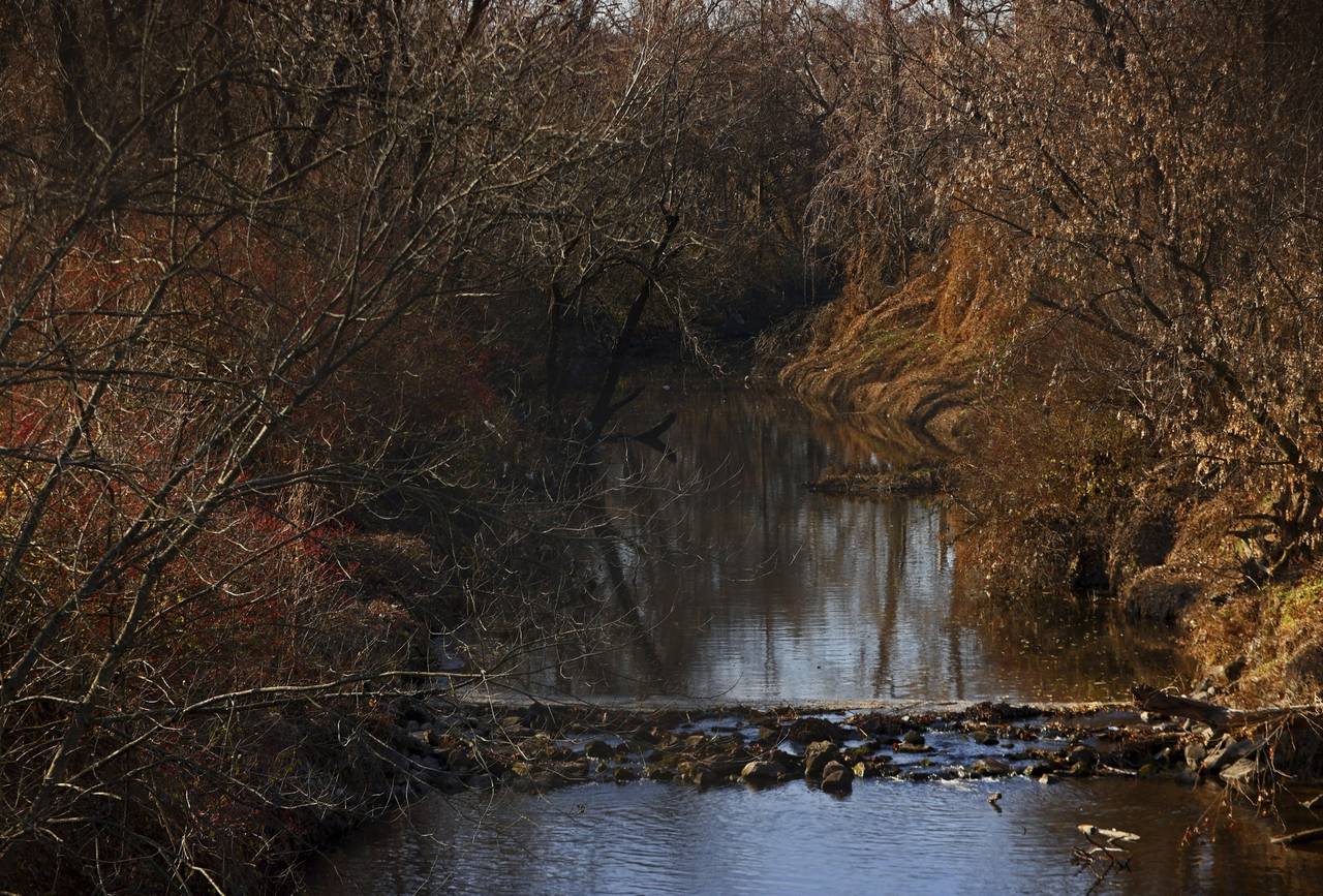 Water flows in Coldwater Creek on Thursday, Dec. 9, 2021, behind a row of homes at Belcroft Drive a...