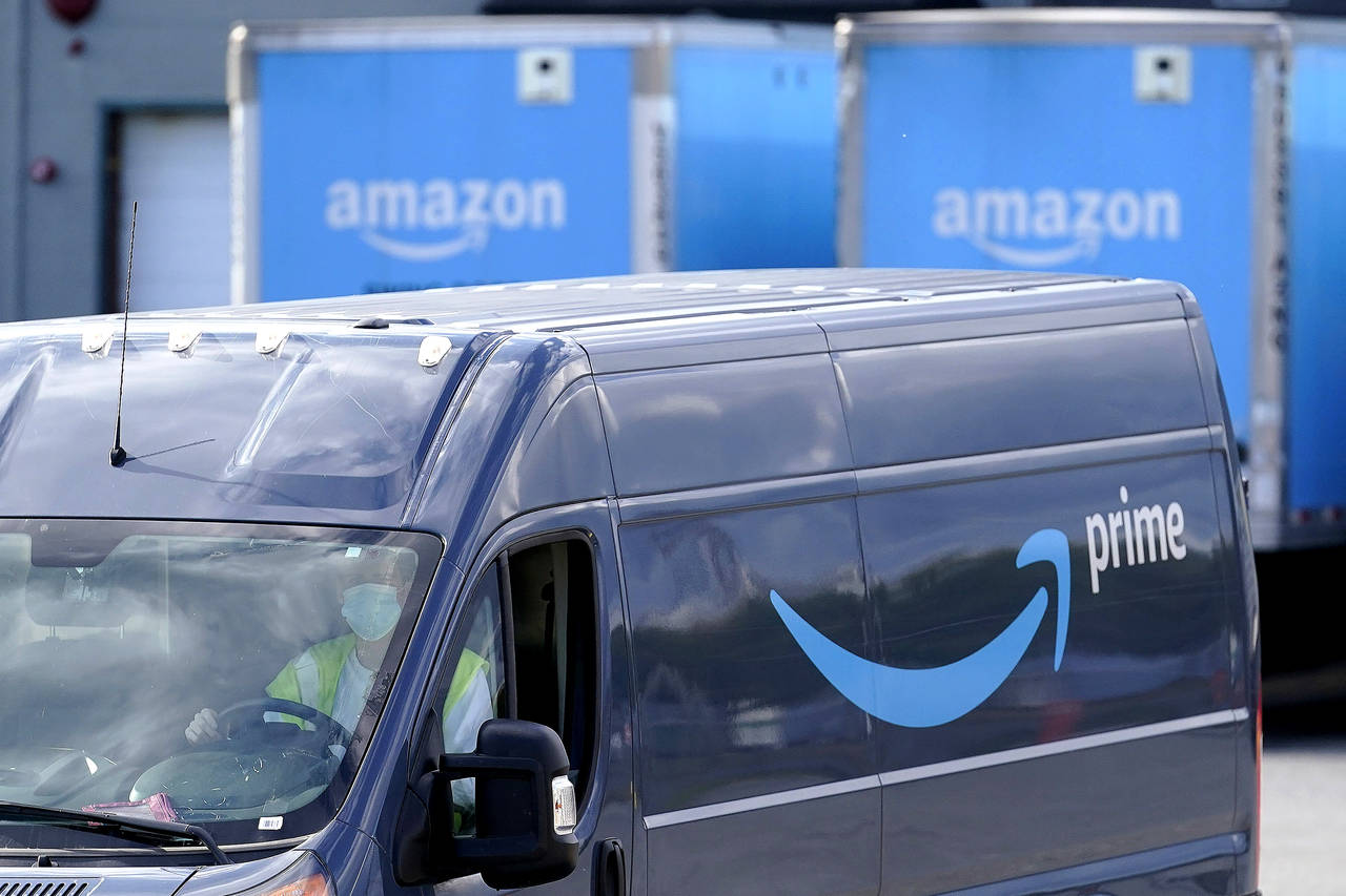 FILE - An Amazon Prime logo appears on the side of a delivery van as it departs an Amazon Warehouse...