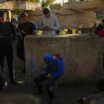 
              People use their phones at a meeting point where the Ukrainian army provides temporary connection in the recently retaken village of Borova, east Ukraine, Friday, Oct. 7, 2022. (AP Photo/Francisco Seco)
            