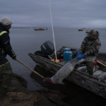 
              Seal hunters Thomas Pootoogooluk, left, and Anthony unload seals onto the edge of the lagoon in Shishmaref, Alaska, Tuesday, Oct. 4, 2022. (AP Photo/Jae C. Hong)
            