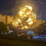 
              In this handout photo released by Kooperativ Telegram Channel, flames and smoke rise from the scene after a warplane crashed into a residential area in Yeysk, Russia, Monday, Oct. 17, 2022. The Russian military says one of its warplanes has crashed near an apartment building in Yeysk, a port city on the Sea of Azov, after experiencing engine failure on takeoff. The crash ignited a huge fire, killing at least four people, leaving six missing and injuring 21 others, eight of whom were in grave condition. One of the pilots, right, descends on a parachute. (Kooperativ Telegram Channel via AP)
            