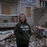 
              Tetiana Pysmeniuk, 40, stands next to the rubble of a her brother's apartment, hit by a Russian missile in Mykolaiv, Sunday, Oct. 23, 2022. (AP Photo/Emilio Morenatti)
            