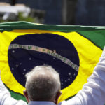 
              Former Brazilian President Luiz Inacio Lula da Silva, who is running for president again, holds a Brazilian flag after voting in a presidential run-off election in Sao Paulo, Brazil, Sunday, Oct. 30, 2022.(AP Photo/Marcelo Chello)
            