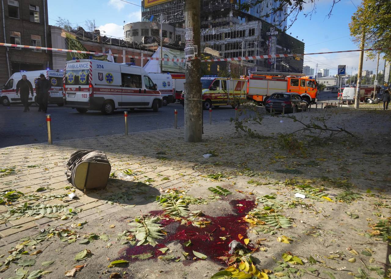 FILE - Blood on the ground at the scene of Russian shelling, in Kyiv, Ukraine, Monday, Oct. 10, 202...