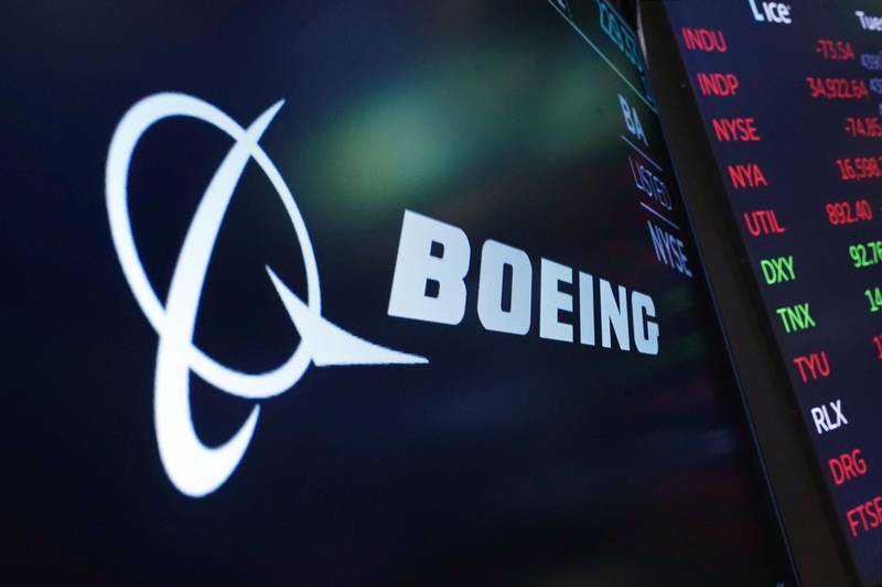 The logo for Boeing appears on a screen above a trading post on the floor of the New York Stock Exc...