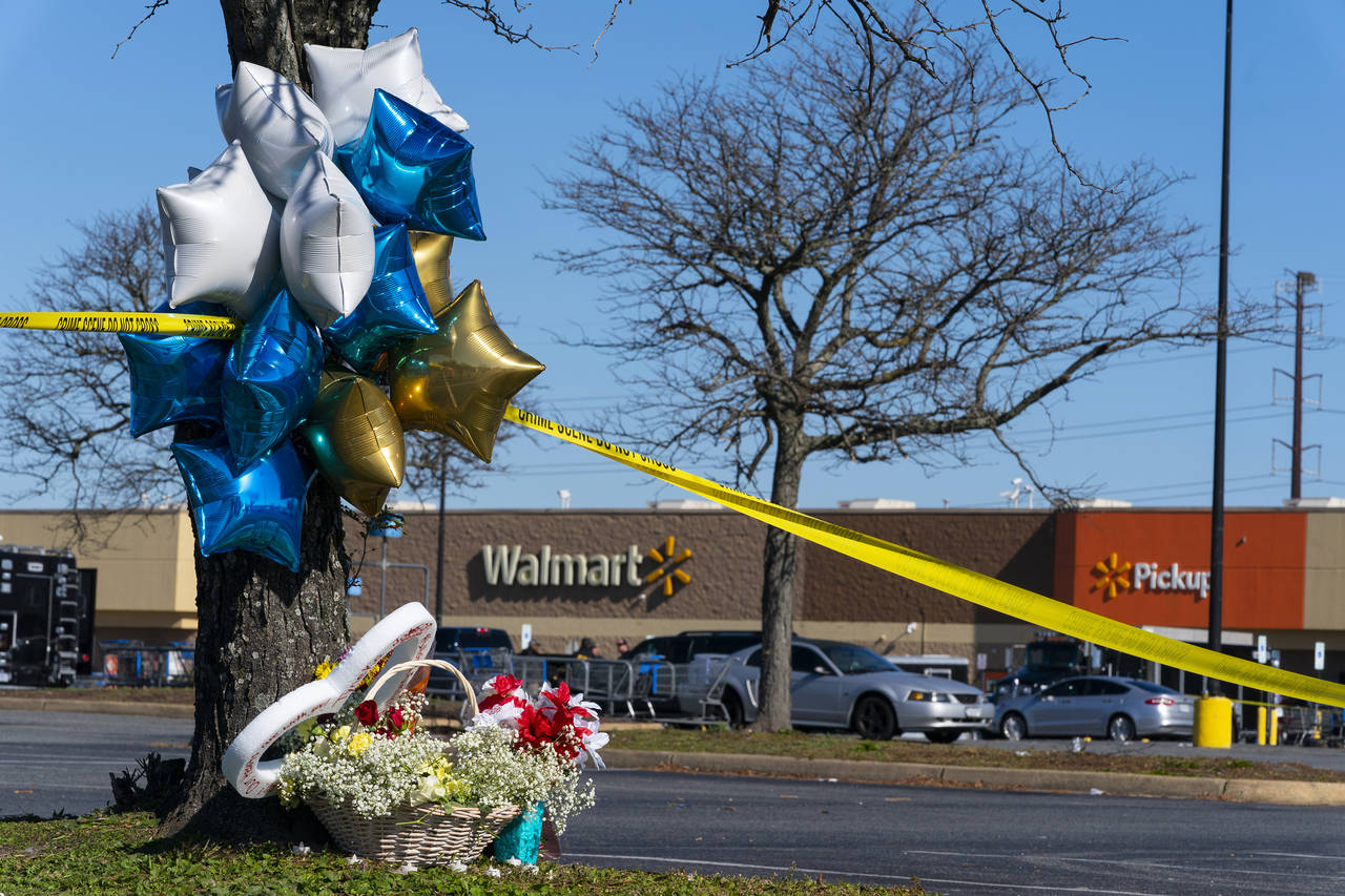 Flowers and balloons have been placed near the scene of a mass shooting at a Walmart, Wednesday, No...