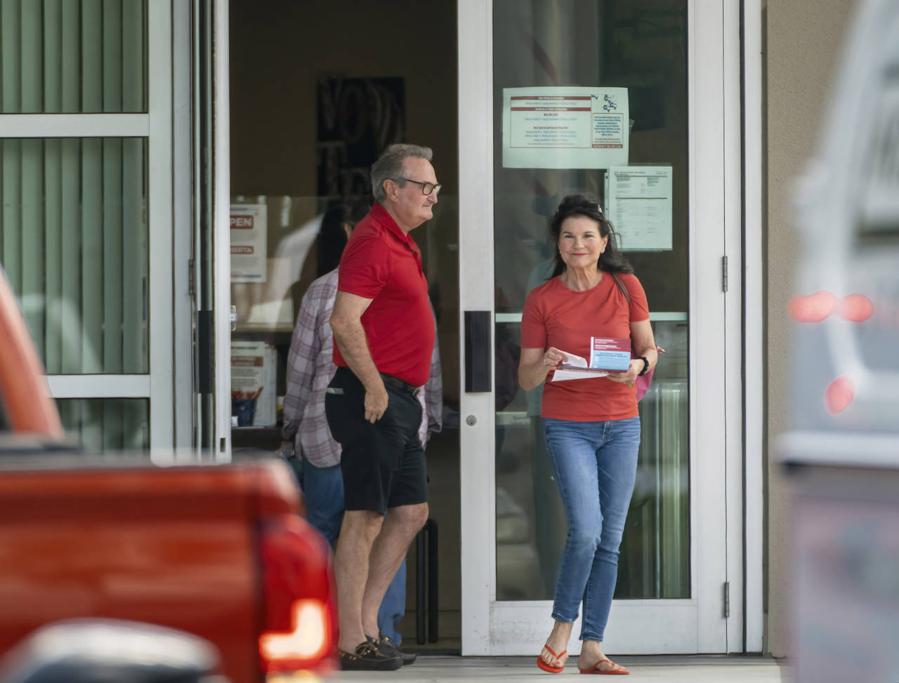 FILE - Voters exit the polls after casting their ballots on the first day of early voting at the Su...