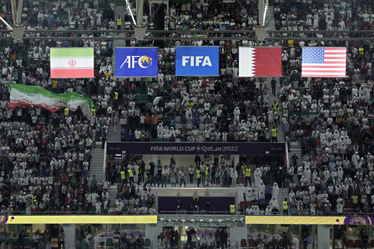 The flags of Iran, left, and the United States, right, hang above the stadium during the World Cup ...