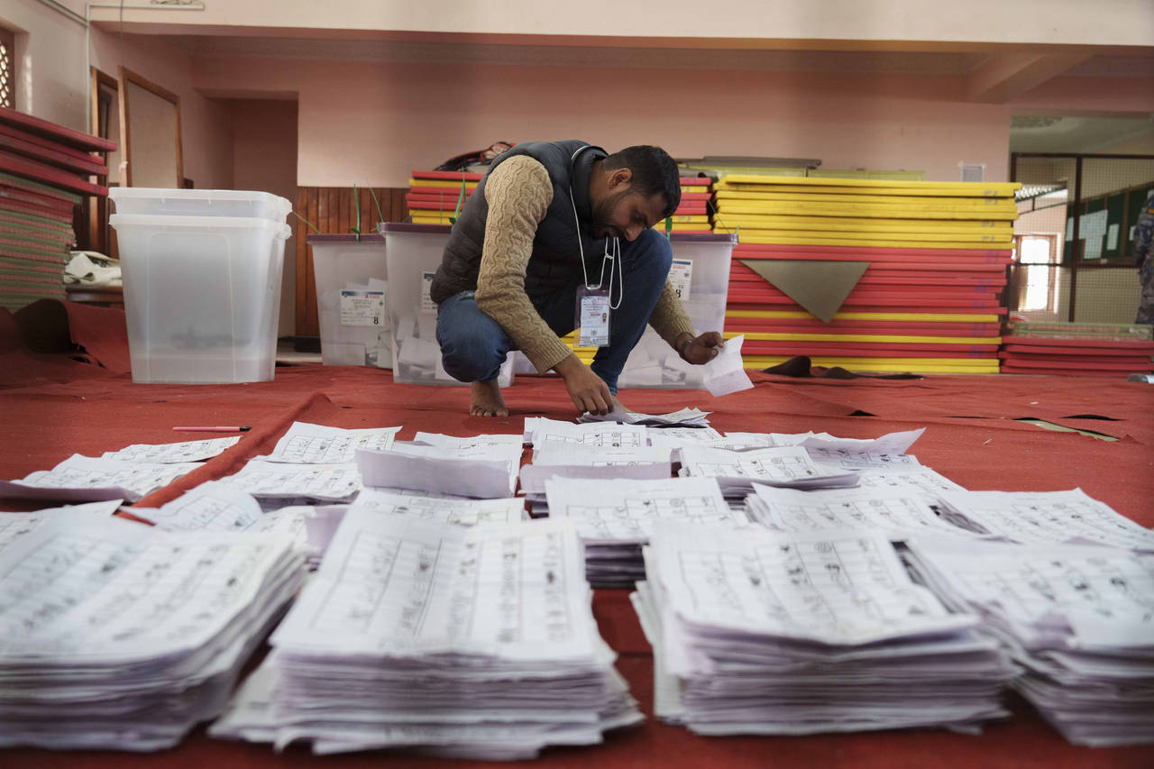 FILE- An election commission staff separates ballot papers to count a day after the general electio...