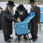 
              Ultra-Orthodox Jews watch their Rabbi Israel Hager votes during Israel elections in Bnei Brak, Tuesday, Nov. 1, 2022. Israel is holding its fifth election in less than four years. (AP Photo/Oded Balilty)
            