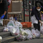
              Workers wearing face masks preparing their customer's online order groceries outside a supermarket in Beijing, Monday, Nov. 28, 2022. Authorities eased anti-virus rules in scattered areas but affirmed China's severe "zero- COVID" strategy Monday after crowds demanded President Xi Jinping resign during protests against controls that confine millions of people to their homes. (AP Photo/Andy Wong)
            