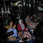 
              Injured survivors are being treated under a makeshift tent at a hospital in Cianjur, Indonesia late Monday, Nov. 21, 2022. Rescuers on Tuesday struggled to find more bodies from the rubble of homes and buildings toppled by the earthquake that killed a number of people and injured hundreds on Indonesia's main island of Java. (AP Photo/Tatan Syuflana)
            