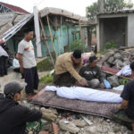 
              Men prepare the body of a young earthquake victim for burial in Cianjur, West Java, Indonesia Tuesday, Nov. 22, 2022. The earthquake has toppled buildings on Indonesia's densely populated main island, killing a number of people and injuring hundreds. (AP Photo/Tatan Syuflana)
            