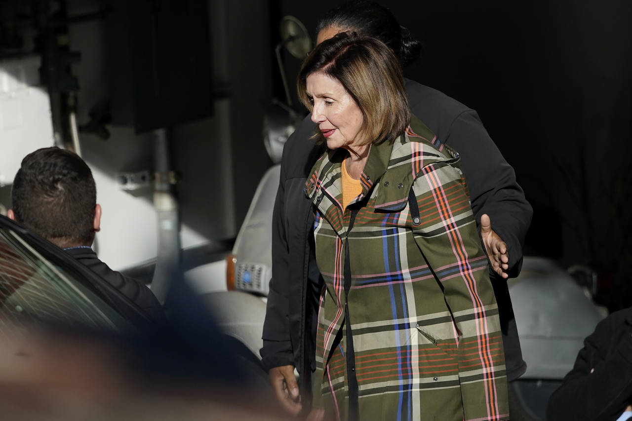 House Speaker Nancy Pelosi is escorted to a vehicle outside of her and husband Paul Pelosi's home i...