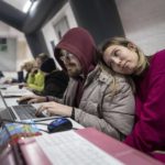 
              A couple uses a laptop at the heating tent "Point of Invincibly" in Bucha, Ukraine, Monday, Nov. 28, 2022. (AP Photo/Evgeniy Maloletka)
            