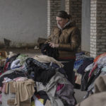 
              Kateryna, 36, a kitchen worker of the Puscha Vodytsia maternity hospital, looks for clothes at a distribution space in the village of Moshun, outside Kyiv, Ukraine, Friday, Nov. 4, 2022. (AP Photo/Andrew Kravchenko)
            