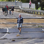 
              Residents walk through the flood damaged roads in the town of Canowindra, in the Central West New South Wales, Australia, Tuesday, Nov. 15, 2022. A rare third consecutive La Niña weather pattern, which is associated with above-average rainfall in eastern Australia, has created a flooding emergency across large swathes of New South Wales that has lasted for two months.(Murray McCloskey/AAP Image via AP)
            