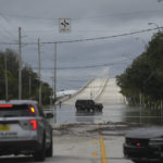 
              Police block off a flooded road following the passage of Hurricane Nicole, Thursday, Nov. 10, 2022, in Vero Beach, Fla. (AP Photo/Rebecca Blackwell)
            