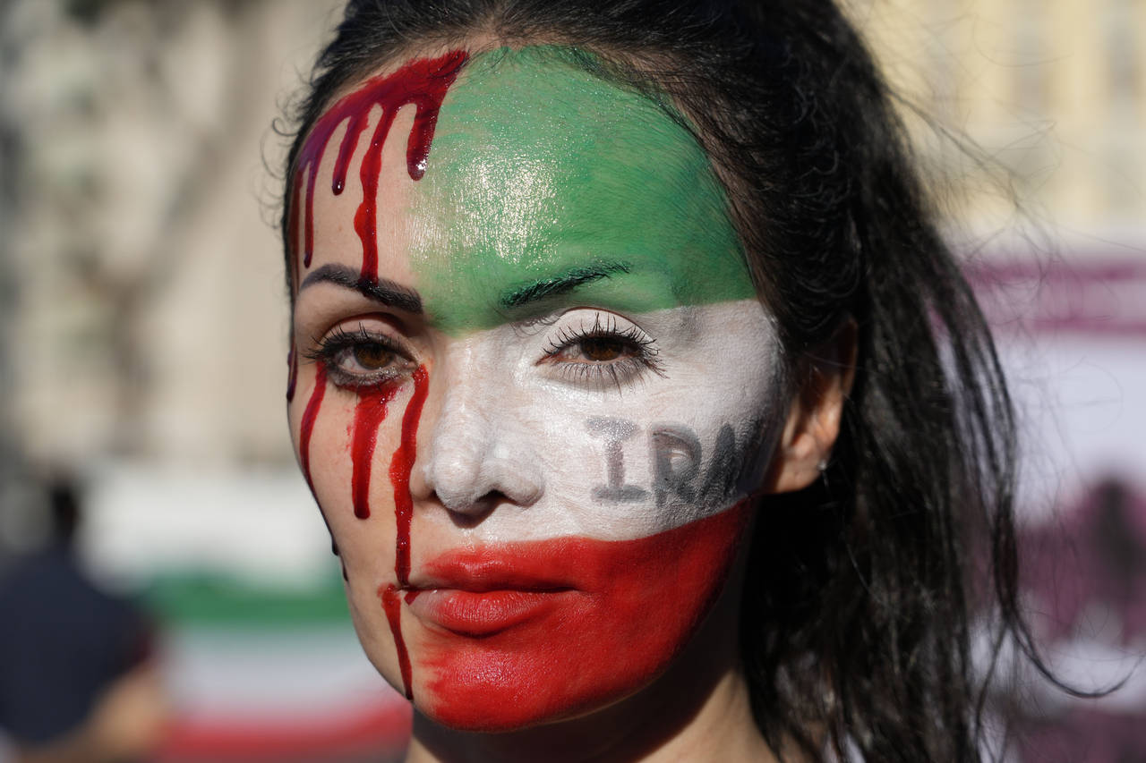 A woman is painted on a her face during a protest against the death of Mahsa Amini, a woman who die...