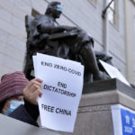 
              A demonstrator stands beside the John Harvard Statue in Harvard Yard as dozens of students and faculty demonstrate against strict anti-virus measures in China, Tuesday, Nov. 29, 2022, at Harvard University in Cambridge, Mass. Protests in China, which were the largest and most wide spread in the nation in decades, included calls for Communist Party leader Xi Jinping to step down. (AP Photo/Josh Reynolds)
            