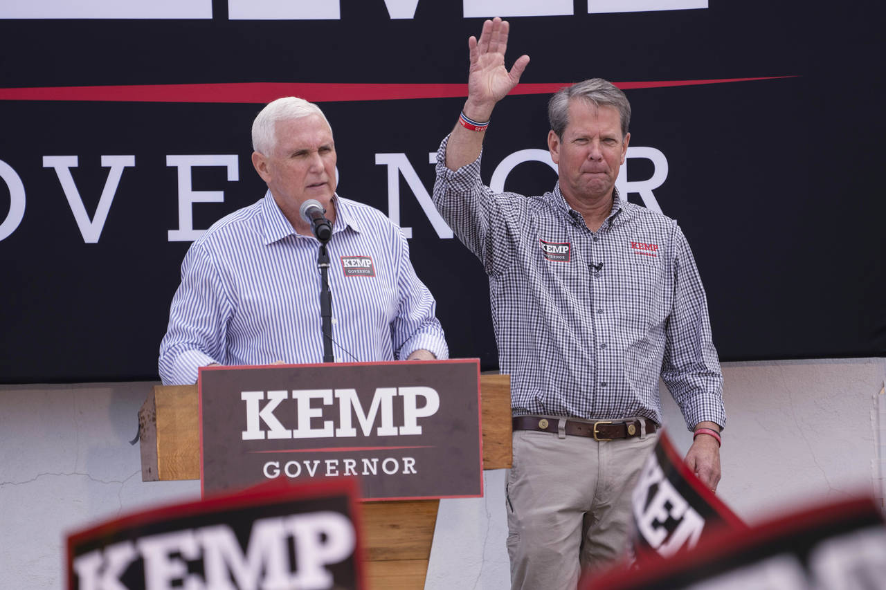 Republican Gov. Brian Kemp, right, reacts as former Vice President Mike Pence speaks during a campa...