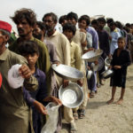 
              FILE - Flood affected people stand in a long line with utensils to get food distributed by Pakistani Army troops in a flood-hit area in Rajanpur, district of Punjab, Pakistan, Aug. 27, 2022. Loss and damage is the human side of a contentious issue that will likely dominate climate negotiations in Egypt. Extreme weather is worsening as the world warms, with a study calculating that human-caused climate change increased Pakistan’s flood-causing rain by up to 50%. (AP Photo/Asim Tanveer, File)
            