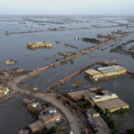 
              FILE - Homes are surrounded by floodwaters in Sohbat Pur city, a district of Pakistan's southwestern Baluchistan province, Aug. 29, 2022. Loss and damage is the human side of a contentious issue that will likely dominate climate negotiations in Egypt. Extreme weather is worsening as the world warms, with a study calculating that human-caused climate change increased Pakistan’s flood-causing rain by up to 50%. (AP Photo/Zahid Hussain, File)
            