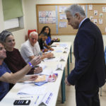 
              Israeli Prime Minister Yair Lapid, right, arrives to cast his vote in the country's fifth election in four years, at a polling station in Tel Aviv Tuesday, Nov. 1, 2022. For the fifth time since 2019, Israelis were voting in national elections on Tuesday, hoping to break the political deadlock that has paralyzed the country for the past three and a half years. (Jack Guez/Pool Photo via AP)
            