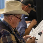 
              Paul Klopfer reads his ballot while voting at a polling center in the South Valley area of Albuquerque, N.M., Tuesday, Nov. 8, 2022 (AP Photo/Andres Leighton)
            